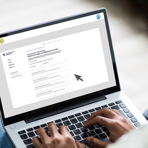 Person füllt auf dem Laptop ein Online-Formular aus.
